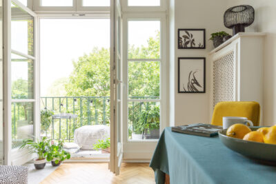 Tenement house with a balcony decorated with plants. Close-up of fruit on a table